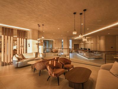 Moderner Hotel-Lounge-Bereich mit bequemen Sesseln, Sofas und warmem Licht.