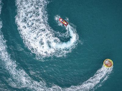 Luftaufnahme eines Jetskis, der eine Schleifenbewegung auf dem Wasser macht.