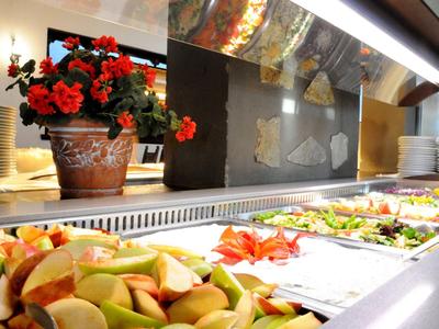 Buffet with various fresh salads and fruits in a restaurant.