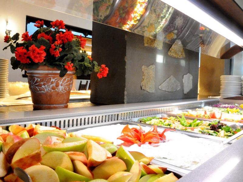 Buffet with various fresh salads and fruits in a restaurant.