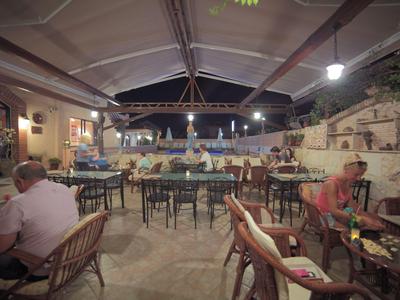 Acogedora terraza de restaurante con clientes y luz suave por la noche.