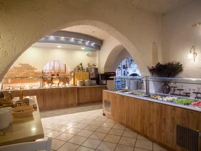 Gran cocina de hotel con dos largas encimeras y techos abovedados de estilo mediterráneo.