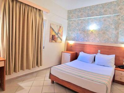 Gemütliches Hotelzimmer mit Doppelbett, Schreibtisch und Vorhängen an einem Fenster.