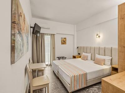 Modernes Hotelzimmer mit Doppelbett, Wandkunst und Fernseher an der Wand.