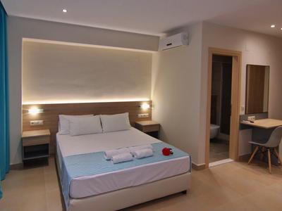 Chambre d'hôtel moderne avec lit double, bureau, chaise et éclairage indirect.