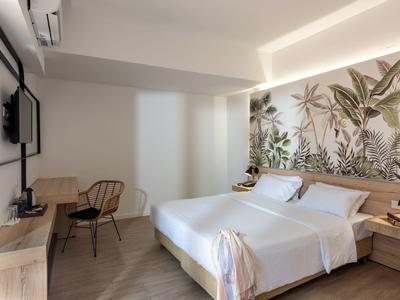 Modernes Hotelzimmer mit Doppelbett, tropischer Wanddekoration, Schreibtisch und Holzvertäfelung.