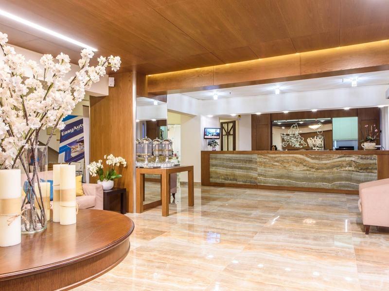 Elegante hotel lobby met houten accenten, marmeren vloer en receptiebalie.