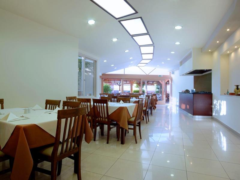 Lichte, moderne eetzaal met bruine tafels en houten stoelen in een hotel.