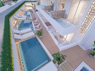 Moderner Poolbereich mit Liegestühlen, Holzterrasse und Glasgeländern in einem hellen Wohnkomplex.