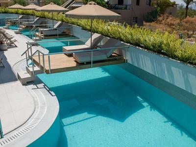 Area piscina esterna di lusso con vasche idromassaggio private e ombrelloni su una terrazza.