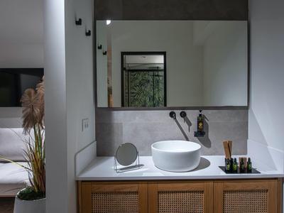 Mobile bagno moderno con lavabo rotondo e grande specchio.