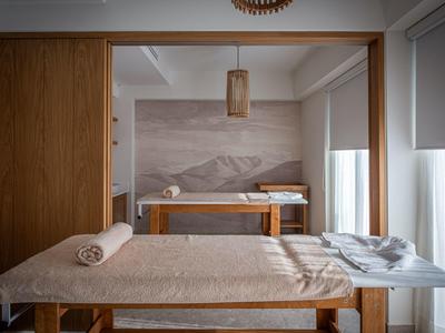 Una stanza per massaggi elegante con due lettini e illuminazione soffusa.