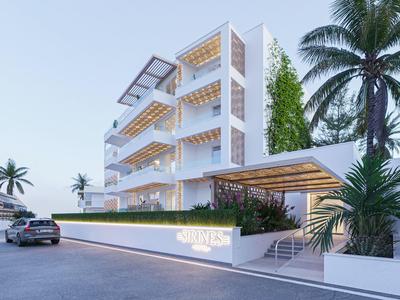 Moderner weißer Wohnkomplex mit großen Balkonen, Palmen und Auto, klare Linien, helle Farben.
