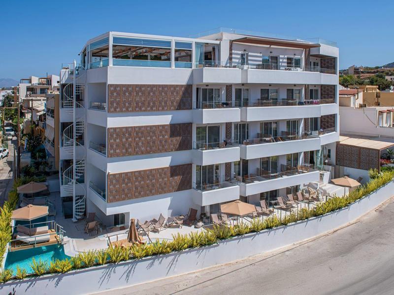 Hotel moderno con piscina e più balconi, ambiente soleggiato.
