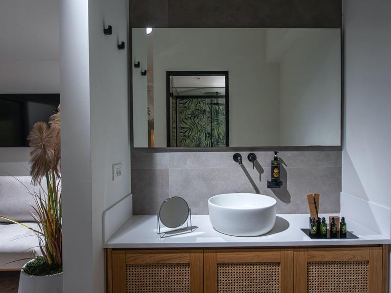 Mobile bagno moderno con lavabo rotondo e grande specchio.