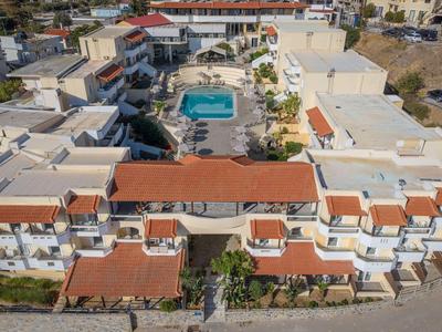 Vista aerea di un hotel con tetti rossi e piscina centrale.