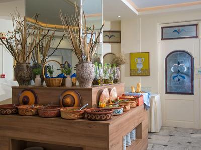 Tavolo del buffet con pane e piante in una zona pranzo luminosa e accogliente.