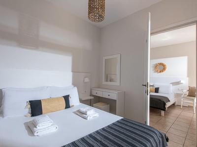 Due camere moderne con design luminoso, pareti bianche e letti ben sistemati.