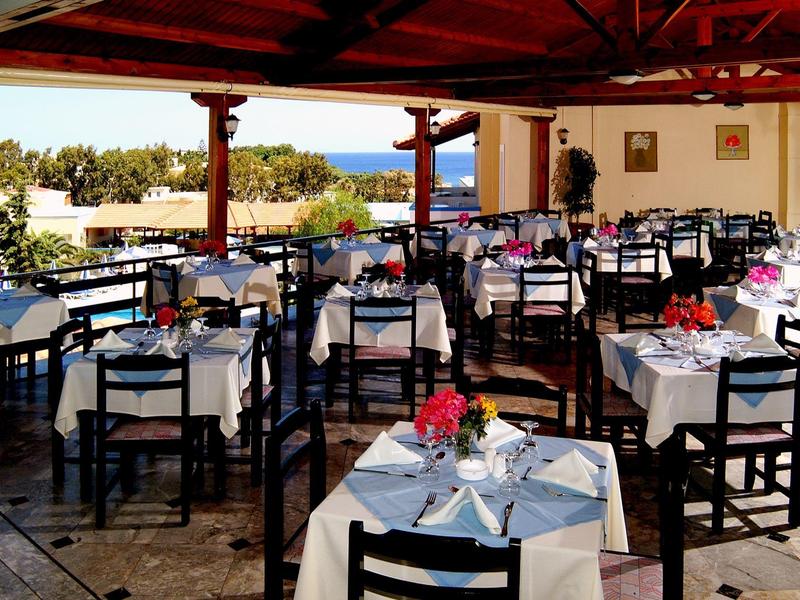 Restaurant élégant avec nappes blanches et vue sur la mer en plein air.