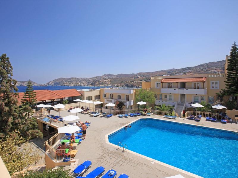Zone de piscine d’hôtel avec chaises longues bleues et parasols sous un ciel clair