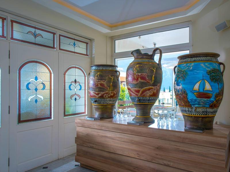 De grands vases en céramique colorée décorent l'entrée avec des portes vitrées et une vue extérieure.