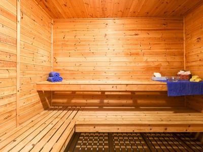 Innensauna mit Holzverkleidung und blauen Handtüchern auf den Bänken.