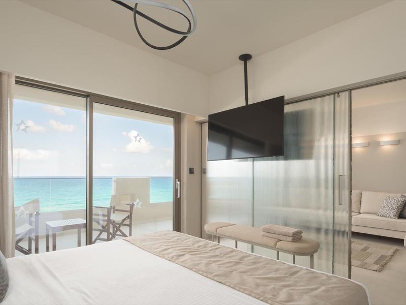 Habitación de hotel moderna con vista al mar, terraza y decoración minimalista.