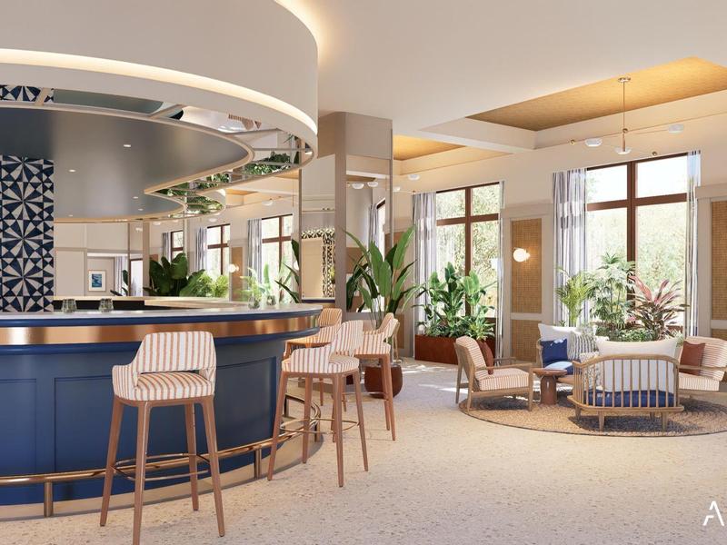 Moderna recepción de hotel con mostrador azul, taburetes de bar y áreas de descanso cómodas a la luz del día.