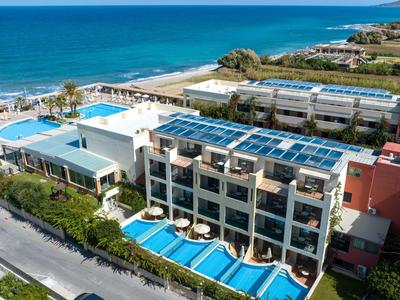 Modernes Hotel mit mehreren Pools direkt am Meer, umgeben von grünen Pflanzen und ruhigen Straßen.