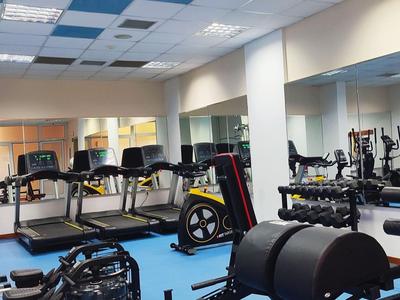 Fitnessruimte met loopbanden, dumbbells en diverse trainingsapparatuur in een hotel