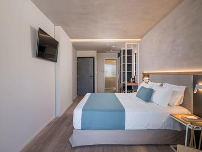 Nowoczesny pokój hotelowy z łóżkiem, telewizorem i stylowym oświetleniem.