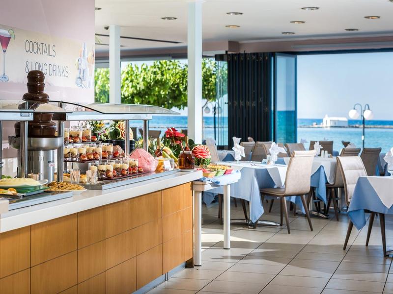 Bufet i jadalnia w nowoczesnej restauracji z widokiem na morze przez duże okna.