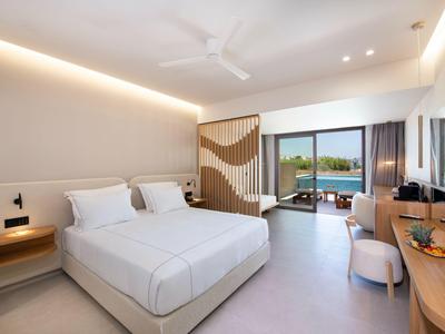 Modern hotel room with two single beds, balcony, and a view of the water landscape.