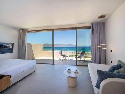 Habitación de hotel moderna con ventana grande, vista al mar, decoración minimalista y balcón.