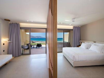 Habitación de hotel moderna con cama grande y terraza con vistas al mar.