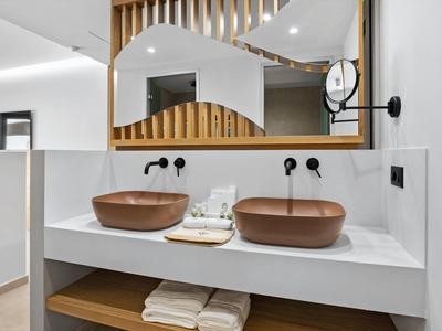 Modernes Badezimmer mit zwei braunen Aufsatzwaschbecken und großem Spiegel darüber.