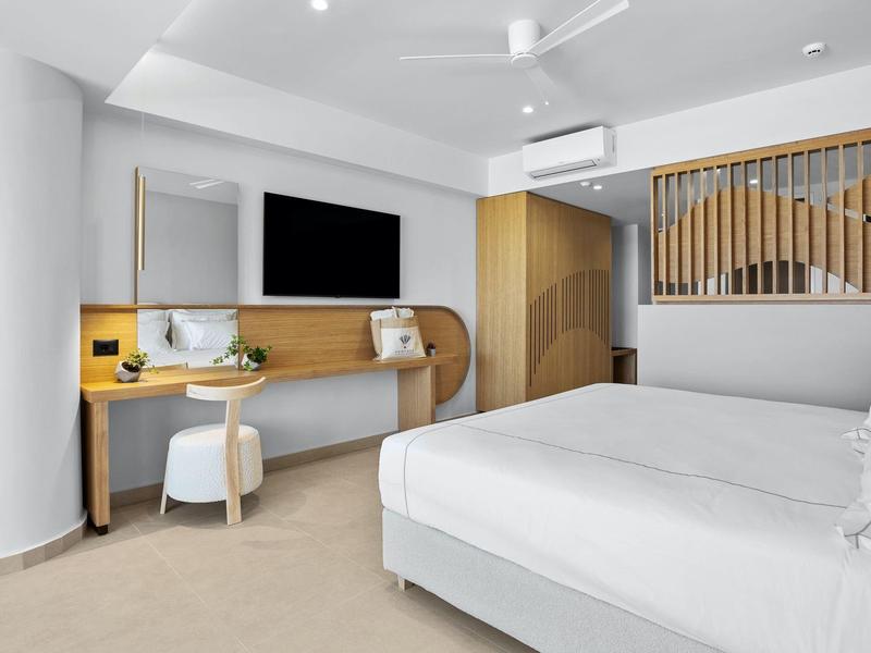 Helles Schlafzimmer mit großem Bett, Holzmöbeln, TV, Arbeitsbereich und modernem Design.