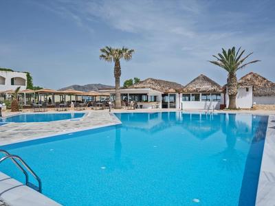 Grande piscina all'aperto con lettini e ombrelloni in un resort soleggiato.