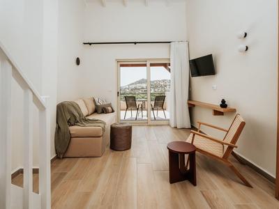 Soggiorno moderno con zona salotto, mobili in legno e accesso al balcone con vista