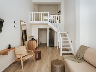 Appartamento moderno con soppalco, area salotto, TV e scala per il mezzanino.