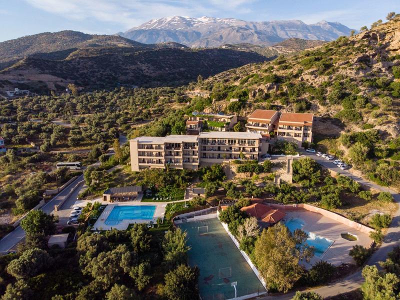 Hotel con piscina immerso in paesaggio montuoso con montagne innevate sullo sfondo