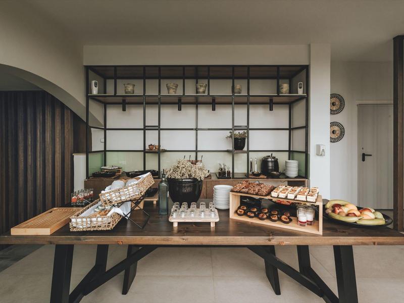 Un tavolo da buffet con vari tipi di pane e pasticceria in una stanza dal design moderno.