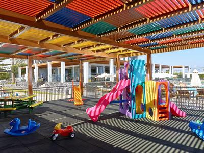 Parco giochi coperto colorato con scivoli e attrezzature su una terrazza dell'hotel.