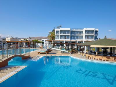 Area piscina moderna dell'hotel con ponte, lettini e ombrelloni in una giornata di sole.
