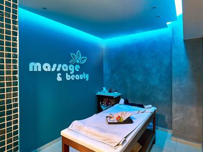 Accogliente sala massaggi con illuminazione blu e lettino comodo in un hotel benessere.