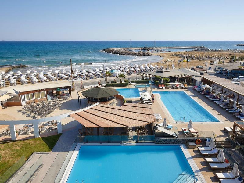 Veduta di un resort con più piscine, lettini, spiaggia e mare sullo sfondo.