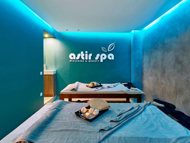 Sala spa moderna con due lettini per massaggi e illuminazione ambientale blu.