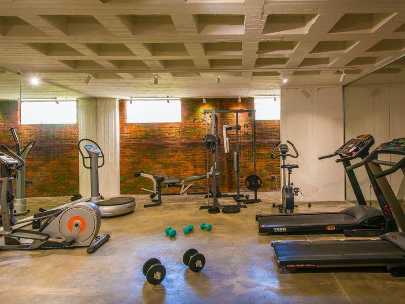 Gimnasio moderno con varios equipos de entrenamiento en el sótano de un hotel.
