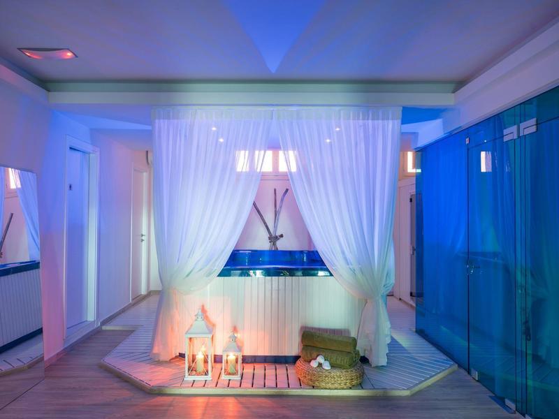 Baño moderno con bañera independiente, cortinas blancas y ambiente azul.