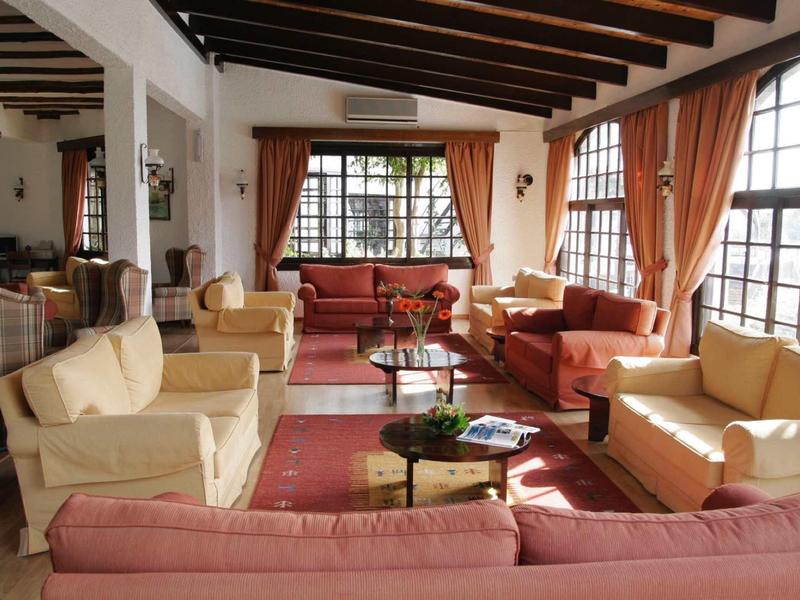 Accogliente area lounge dell'hotel con divani, tappeti e grandi finestre